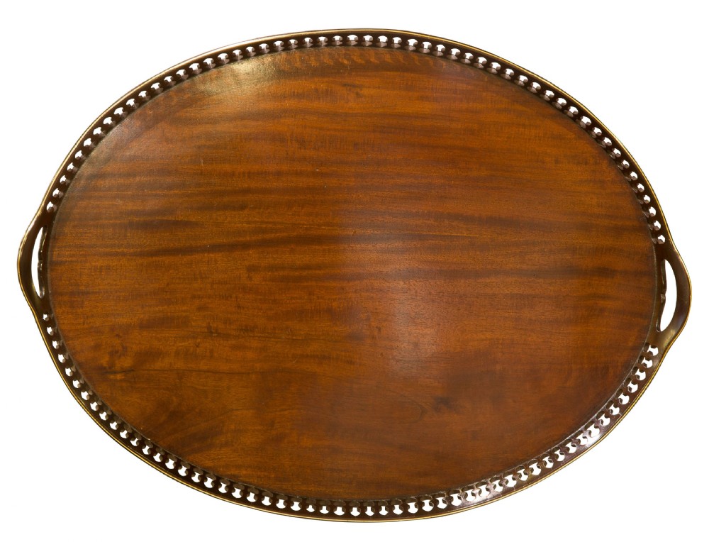 An oval mahogany serving tray with a polished dark wood grain and a raised pierced brass gallery featuring open handle grips. View III