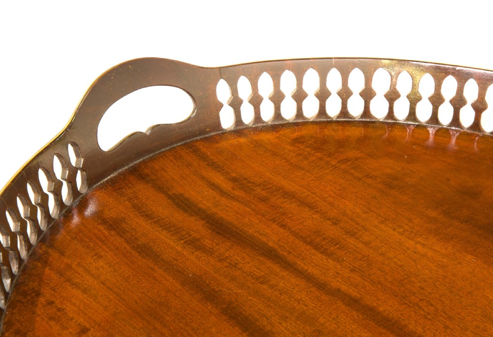 An oval mahogany serving tray with a polished dark wood grain and a raised pierced brass gallery featuring open handle grips. View V