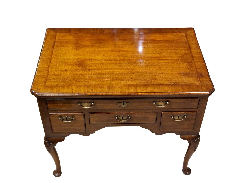 A George II mahogany lowboy table featuring carved cabriole legs, brass drop handles, and four drawers. View IV