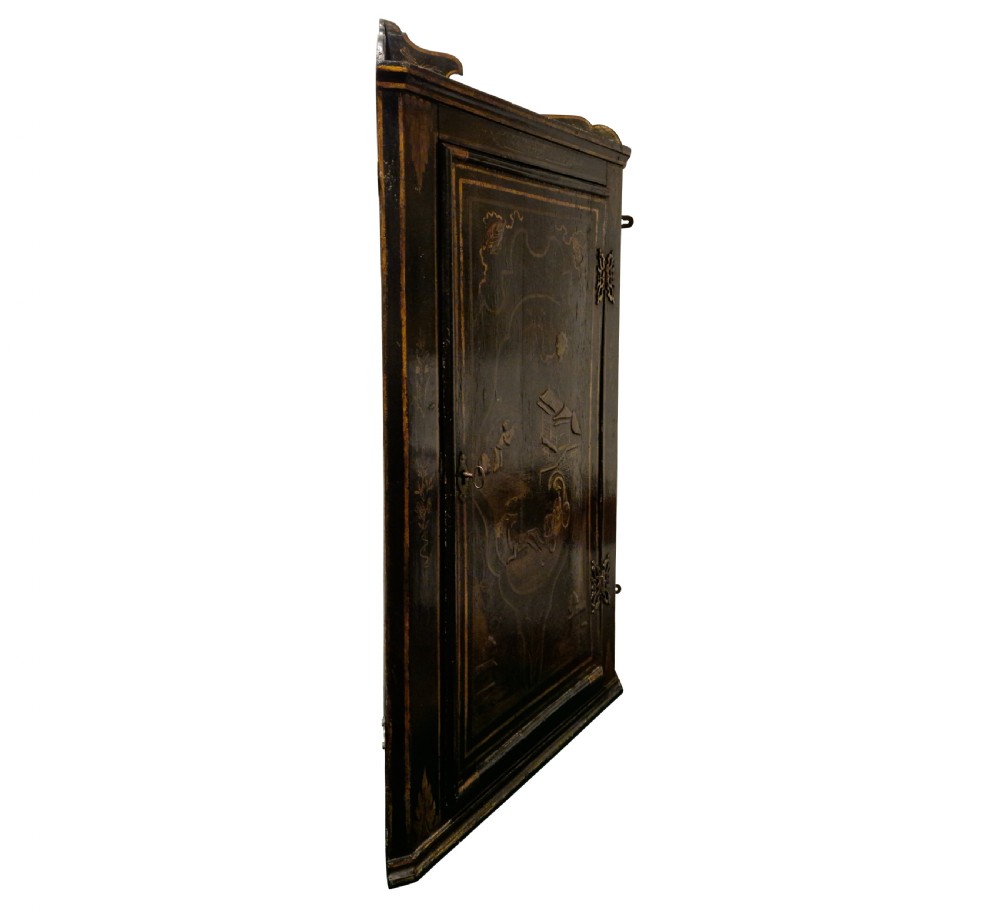 An eighteenth-century black japanned corner cupboard featuring gilded Chinoiserie landscape decorations and ornate brass butterfly hinges. View II