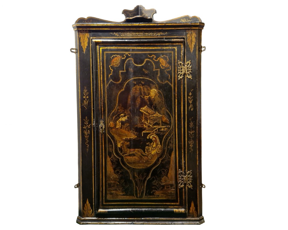 An eighteenth-century black japanned corner cupboard featuring gilded Chinoiserie landscape decorations and ornate brass butterfly hinges. View V