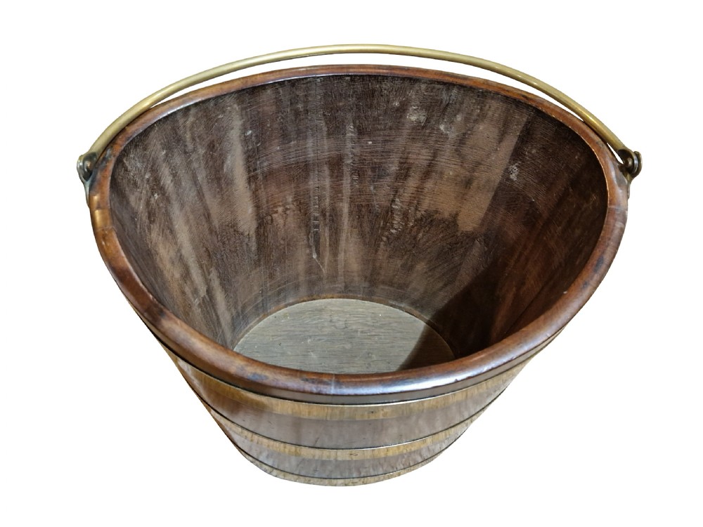 A nineteenth-century tapered mahogany bucket featuring three polished brass bands, a fitted brass interior liner, and a curved top rim. View IV