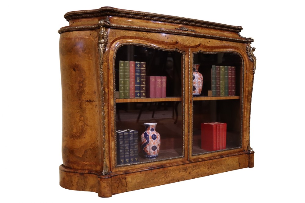 A French Revival burr walnut and kingwood side cabinet featuring two glazed doors, serpentine sides, and gilt-bronze ormolu mounts. View II