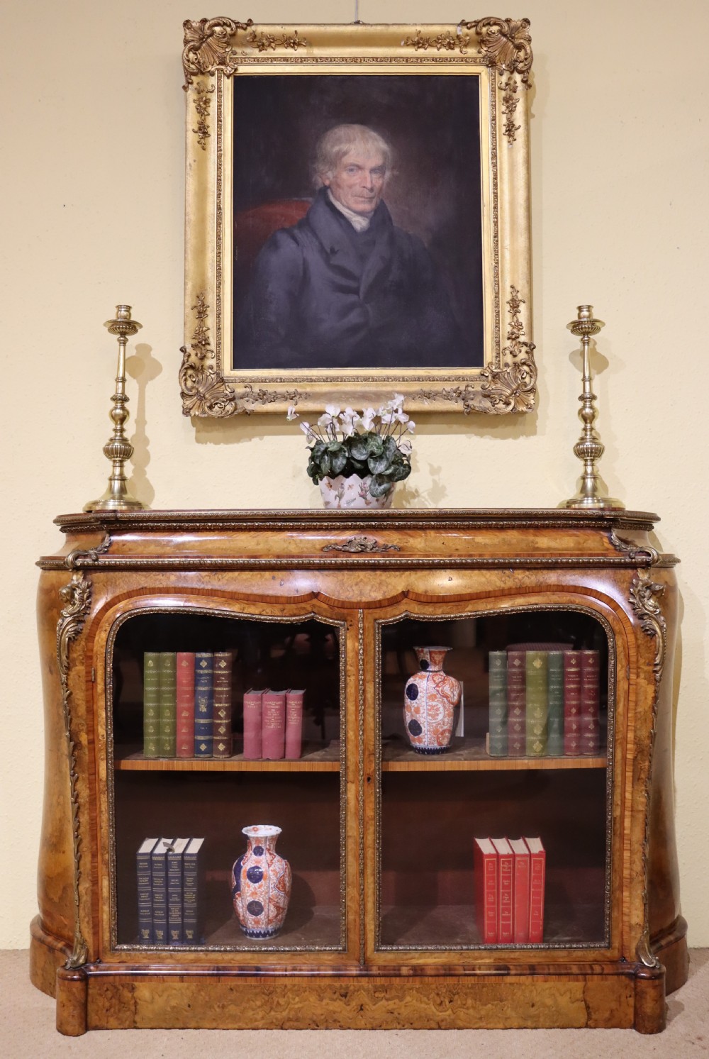 A French Revival burr walnut and kingwood side cabinet featuring two glazed doors, serpentine sides, and gilt-bronze ormolu mounts. View V