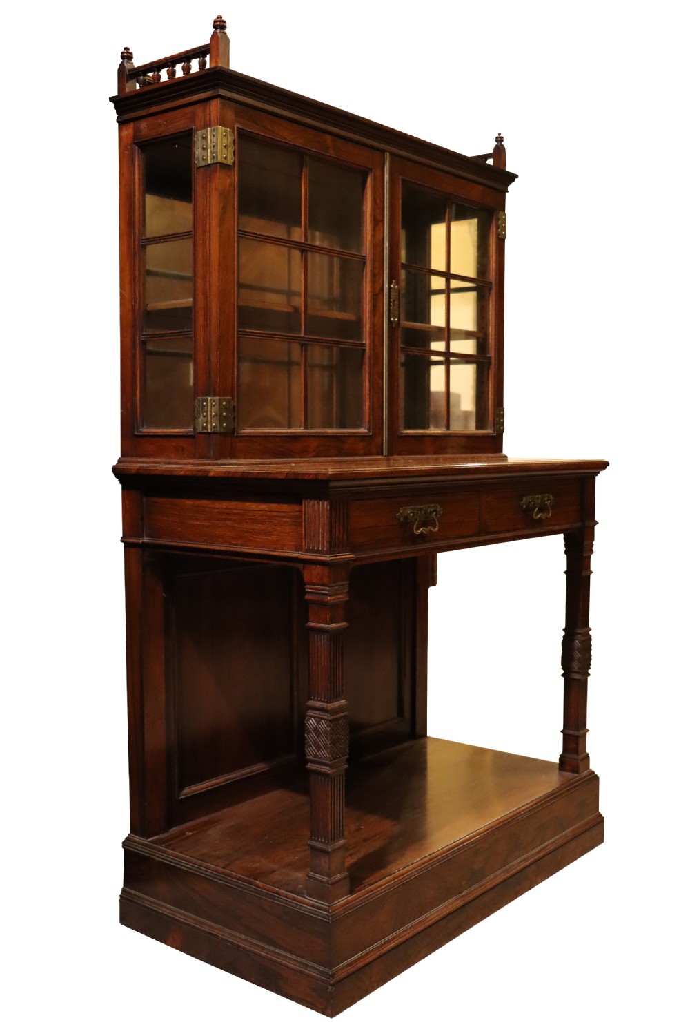 An antique rosewood cabinet on stand featuring glazed double doors, brass corner mounts, two frieze drawers, and an open lower shelf. View II