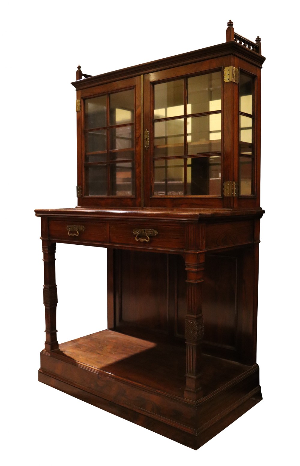 An antique rosewood cabinet on stand featuring glazed double doors, brass corner mounts, two frieze drawers, and an open lower shelf. View III