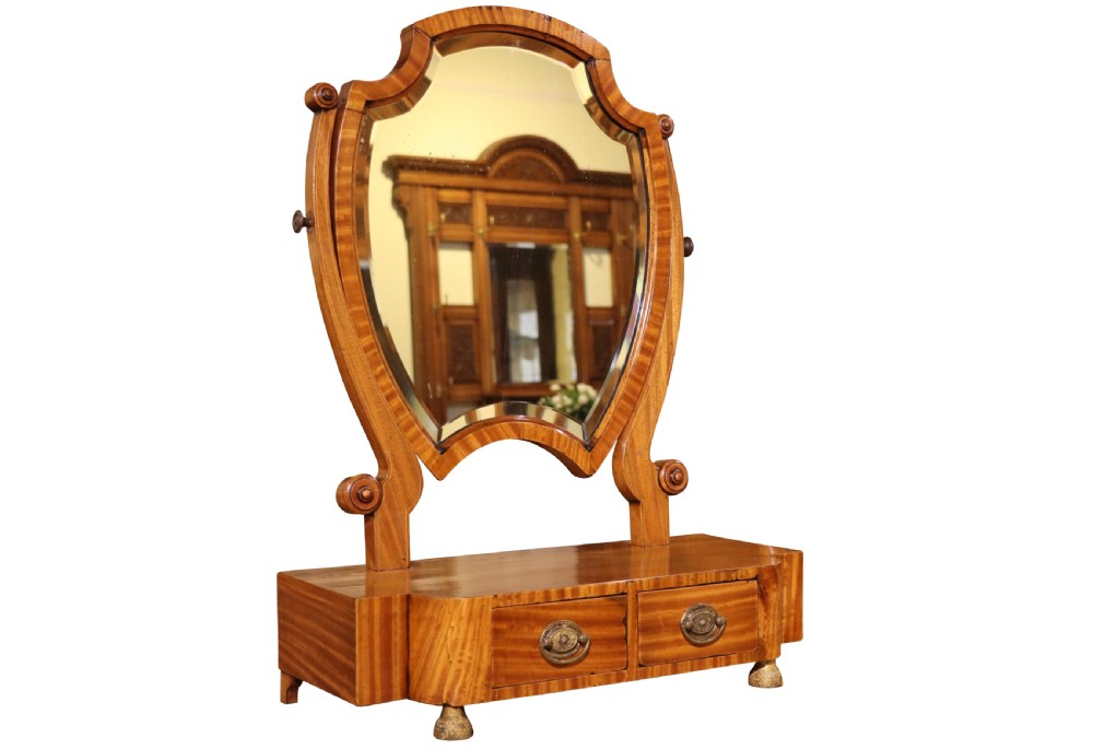 A freestanding antique satinwood dressing table mirror with a shaped bevelled glass frame set above a two-drawer base. View II