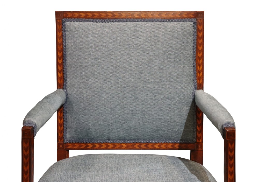 A 19th-century mahogany elbow chair featuring chevron parquetry inlay, padded armrests, square tapered legs, and light blue upholstery. View II