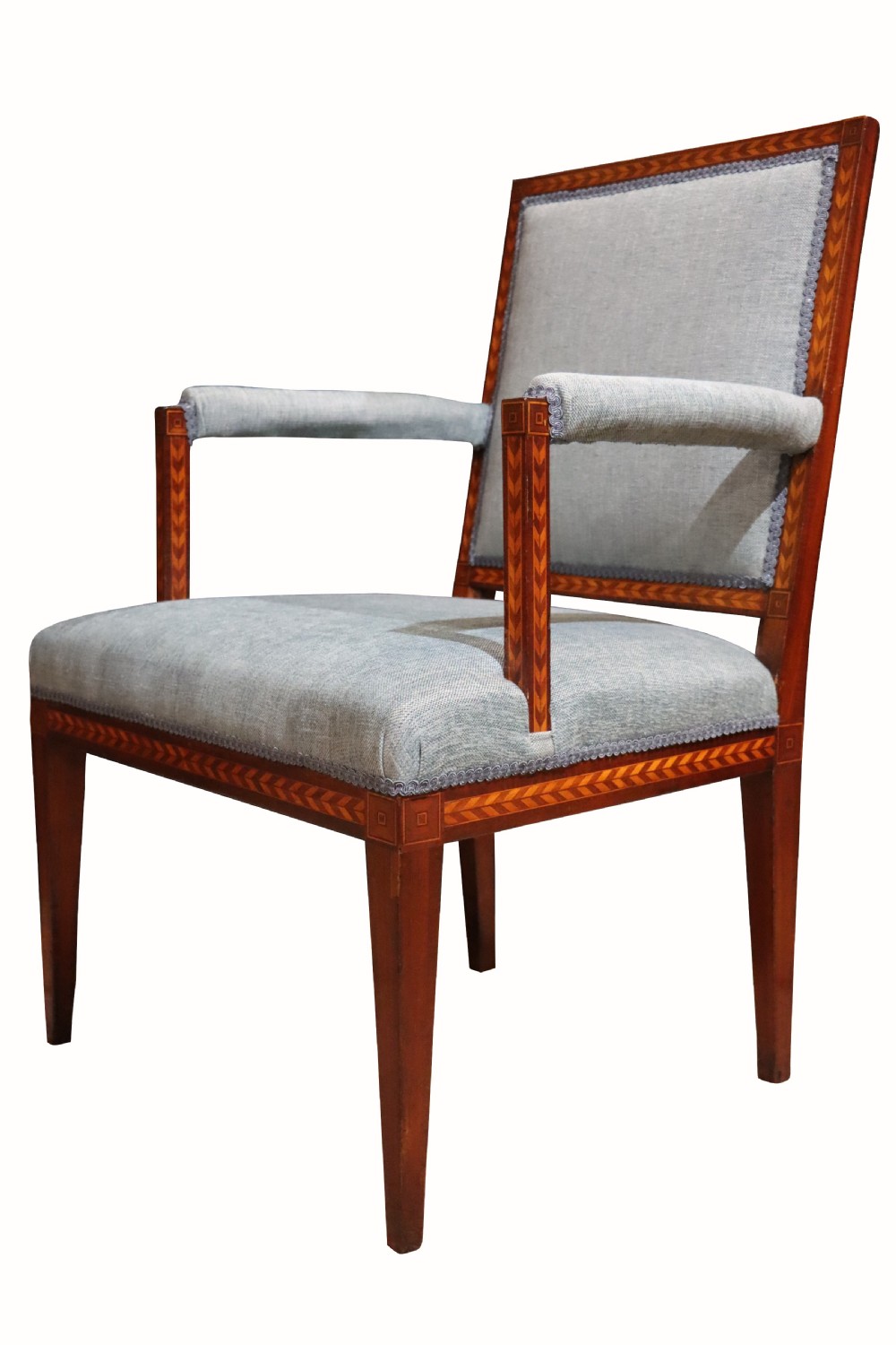 A 19th-century mahogany elbow chair featuring chevron parquetry inlay, padded armrests, square tapered legs, and light blue upholstery. View IV