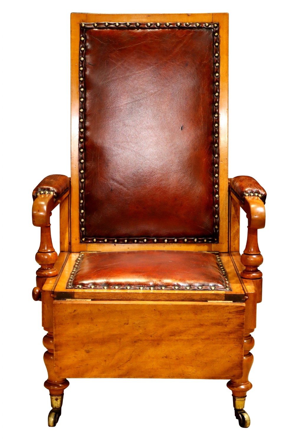 A Victorian childs reclining chair crafted from light timber with studded warm brown leather upholstery, turned arm supports, and brass castors.