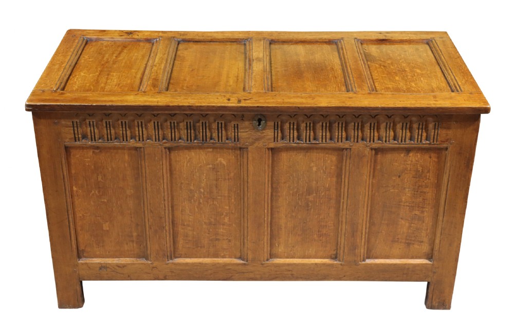 An 18th-century oak panelled coffer featuring four recessed front panels, carved frieze detailing along the top rail, and a central brass escutcheon. View III
