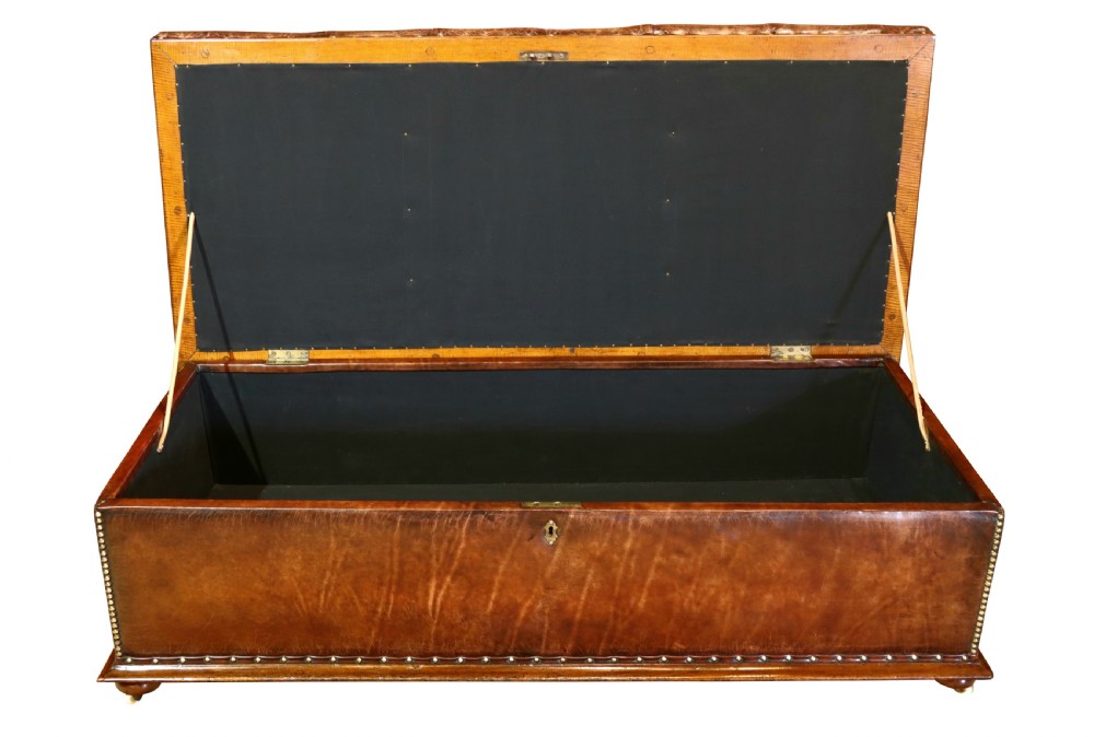 A large 19th-century rectangular leather ottoman with deep buttoned upholstery, brass stud trim, and short wooden feet on castors. View VIII