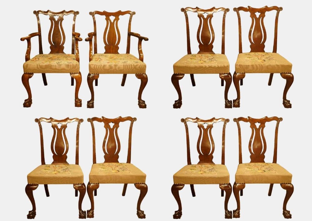 A set of eight mahogany Chippendale style dining chairs featuring carved openwork back splats, tapestry upholstered seats, and cabriole legs with ball and claw feet.