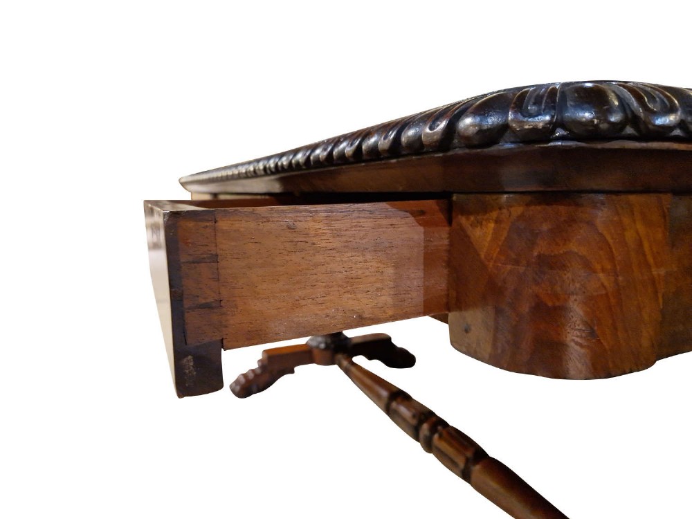 A George IV mahogany partners writing table featuring a patterned top edge, three frieze drawers, carved pedestal supports, a turned stretcher, and claw feet. View VIII