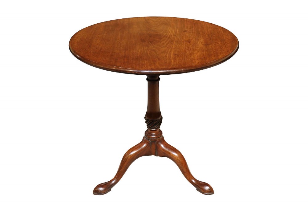 A Georgian mahogany tripod table featuring a circular top, turned central pedestal with spiral carving, and three cabriole legs ending in pad feet.