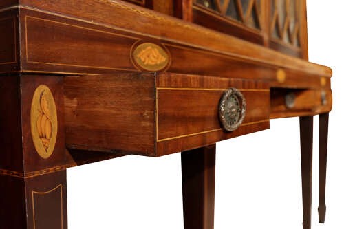 An antique mahogany breakfront display cabinet featuring diamond astragal glazed doors set upon an inlaid stand with square tapered legs. View III