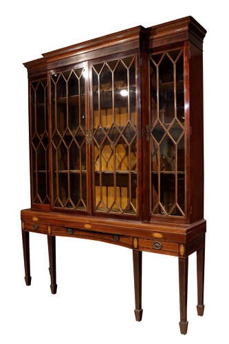 An antique mahogany breakfront display cabinet featuring diamond astragal glazed doors set upon an inlaid stand with square tapered legs. View IV