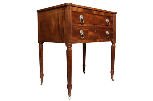 A Regency mahogany writing table with two drawers featuring brass lion-mask ring handles and reeded legs on brass castors. View II