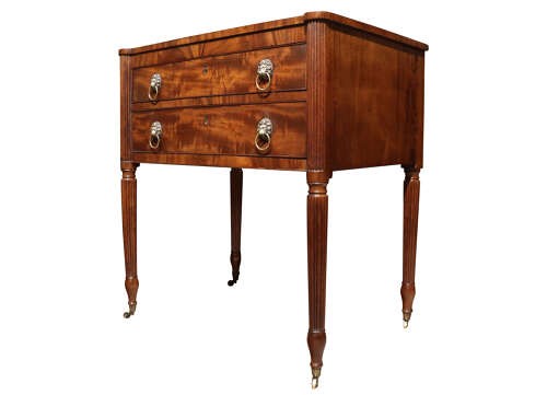 A Regency mahogany writing table with two drawers featuring brass lion-mask ring handles and reeded legs on brass castors. View III