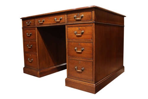 An Edwardian mahogany pedestal desk featuring nine drawers with brass drop handles and a central kneehole opening. View IV