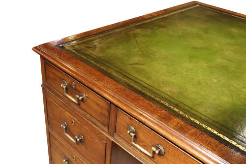 An Edwardian mahogany pedestal desk featuring nine drawers with brass drop handles and a central kneehole opening. View V
