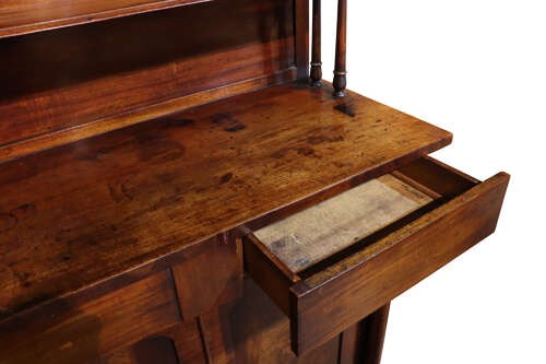A William IV dark mahogany chiffonier featuring a two-tier shelved upper superstructure supported by turned columns above a two-door cupboard base. View IV