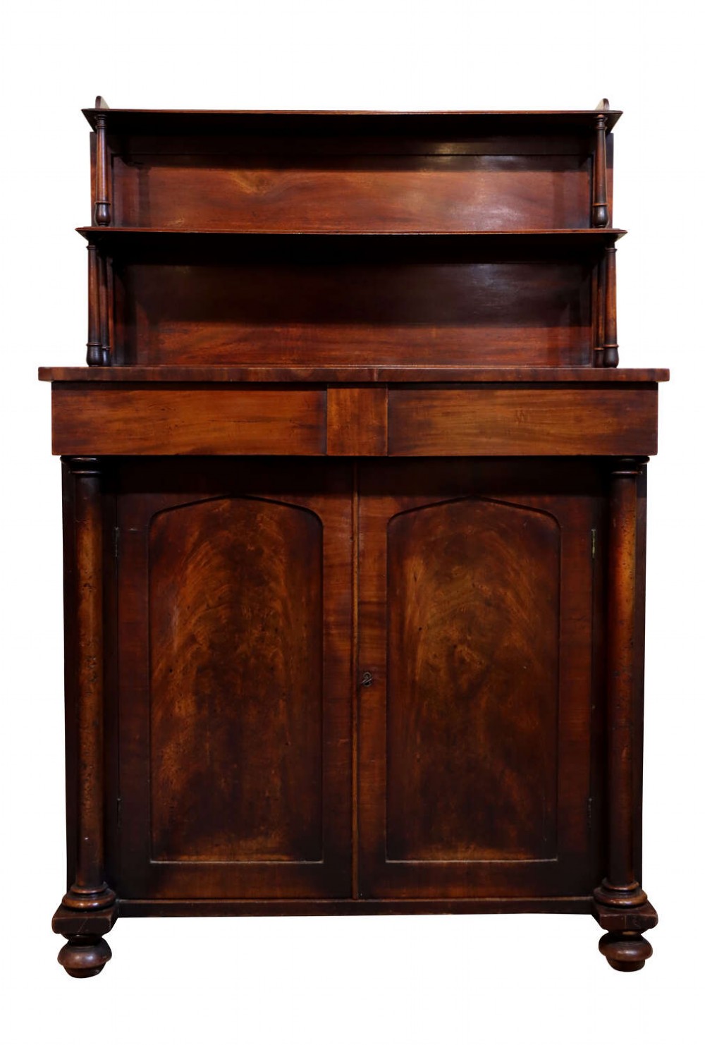 A William IV dark mahogany chiffonier featuring a two-tier shelved upper superstructure supported by turned columns above a two-door cupboard base. View V