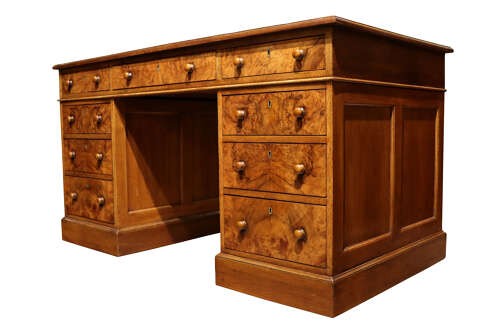 A Victorian burr walnut pedestal desk featuring nine drawers with turned wooden knobs and a red leather gilt-tooled writing surface. View IV