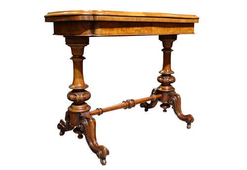 A Victorian burr walnut card table with a fold-over swivel top, carved twin pedestal supports, turned stretcher, and splayed legs on castors. View II