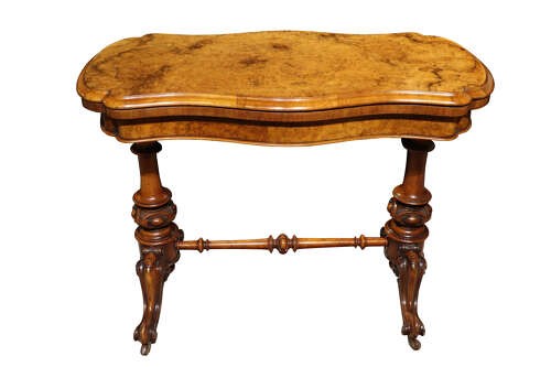 A Victorian burr walnut card table with a fold-over swivel top, carved twin pedestal supports, turned stretcher, and splayed legs on castors. View III