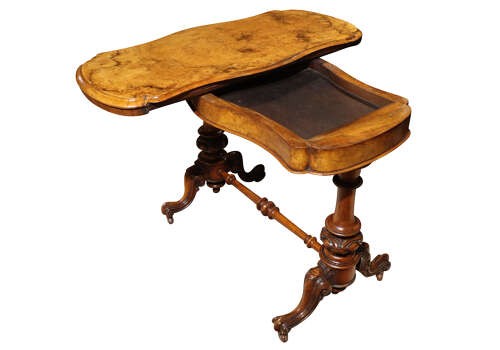 A Victorian burr walnut card table with a fold-over swivel top, carved twin pedestal supports, turned stretcher, and splayed legs on castors. View V