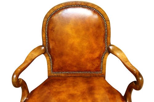 A pair of early twentieth-century walnut armchairs featuring warm tan leather upholstery with brass studding and cabriole legs. View VI