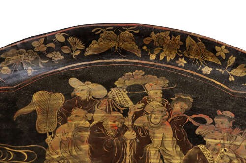 An oval black lacquered tray featuring gilt Chinoiserie decoration of figures on clouds surrounded by a floral border. View IV