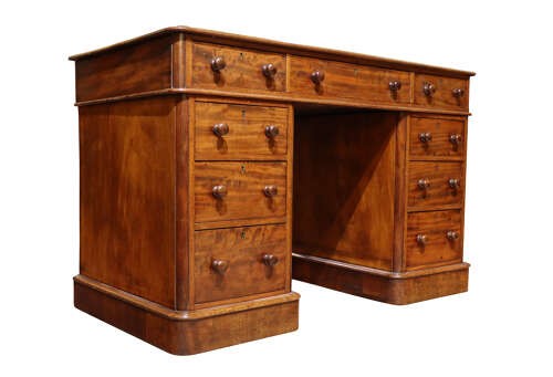 A Victorian mahogany pedestal desk with nine drawers featuring turned wooden handles and a solid plinth base. View II