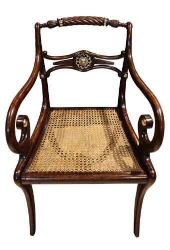 A pair of dark mahogany Regency armchairs featuring swept sabre legs, woven cane seats, rope-twist top rails, and central brass rosette mounts on the backrest splats. View VI