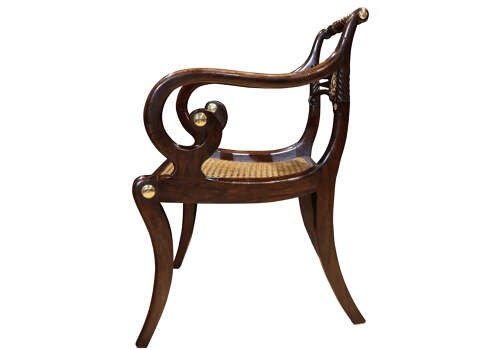 A pair of dark mahogany Regency armchairs featuring swept sabre legs, woven cane seats, rope-twist top rails, and central brass rosette mounts on the backrest splats. View VII