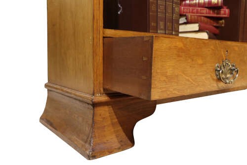Late 19th-century open oak bookcase featuring three tiers of shelving, two lower drawers with brass drop handles, and a moulded top cornice. View V