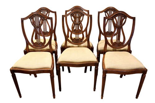 A set of eight mahogany dining chairs with carved lyre backs, fluted legs, and neutral upholstered seats. View IV