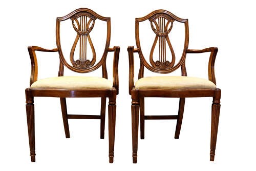 A set of eight mahogany dining chairs with carved lyre backs, fluted legs, and neutral upholstered seats. View V