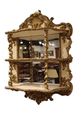 A French Rococo Revival painted and gilt wall etagere featuring three shelves, carved scrollwork, spiral columns, and a mirrored back. View III