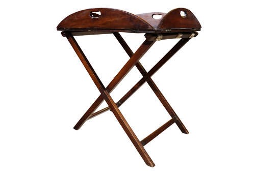 A William IV mahogany butlers tray with carved cutout handles situated on an X-frame folding wooden stand. View IV
