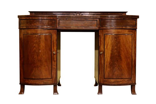 A Regency flame mahogany bow-front pedestal sideboard featuring a low back gallery, central frieze drawer, and two flanking cupboard pedestals on tapered feet. View II