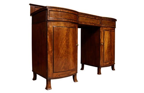 A Regency flame mahogany bow-front pedestal sideboard featuring a low back gallery, central frieze drawer, and two flanking cupboard pedestals on tapered feet. View III