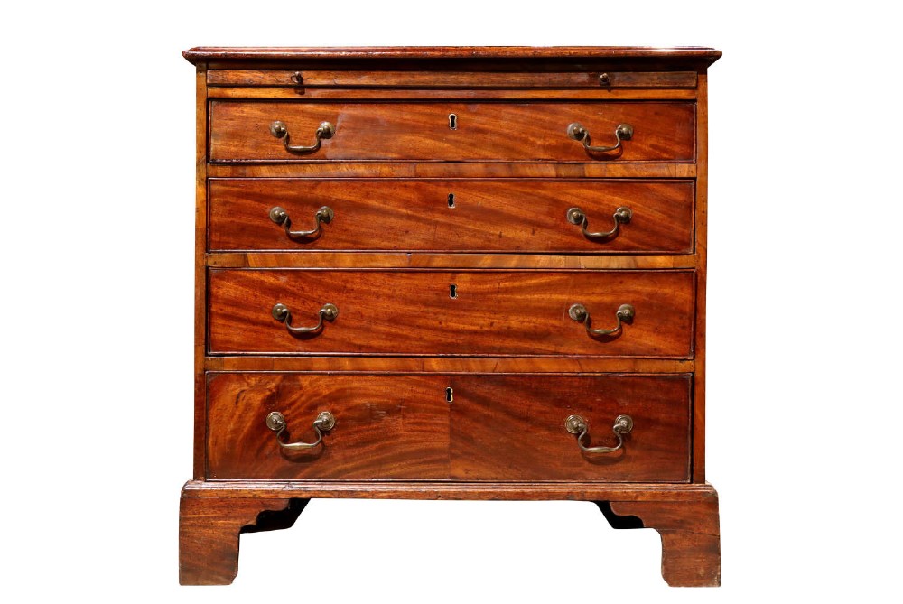 A small George III mahogany chest of drawers featuring four graduated drawers with brass swan-neck handles, a pull-out brushing slide, and bracket feet.
