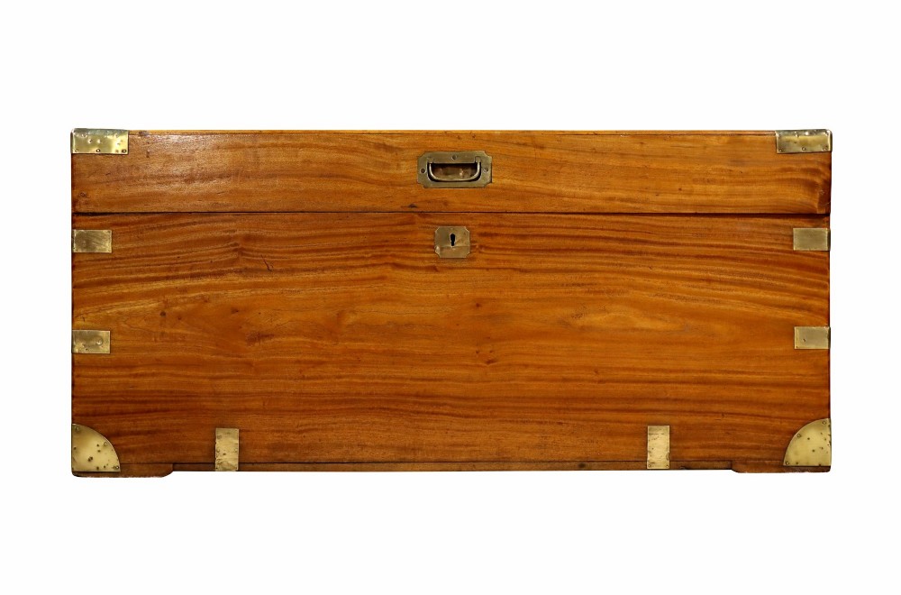 A nineteenth-century camphor wood campaign trunk featuring polished warm timber grain and protective brass corner plates and drop handles. View II