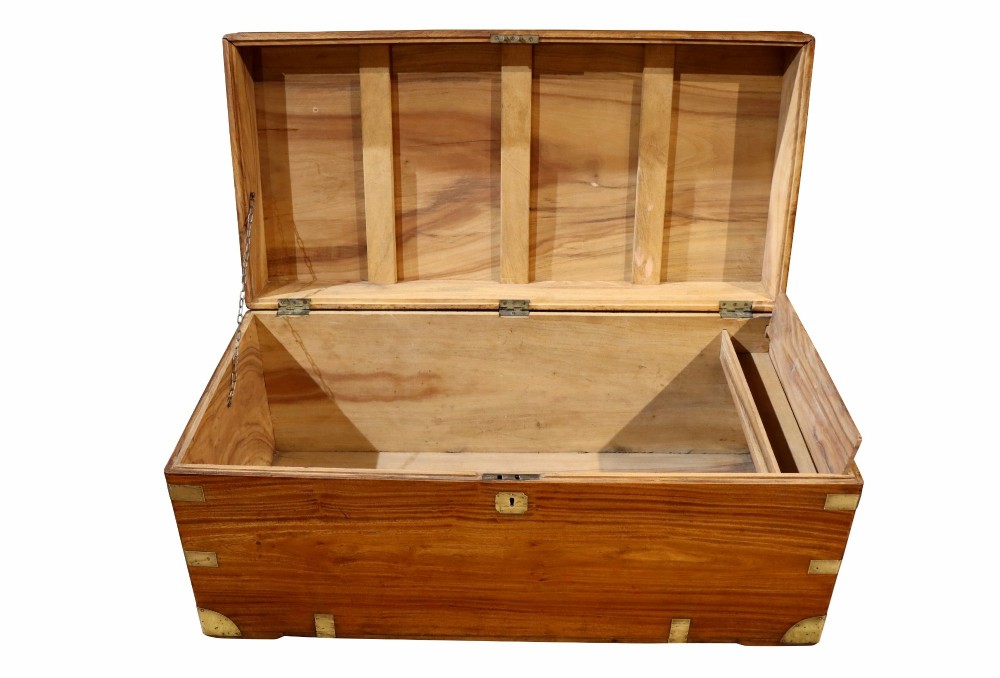 A nineteenth-century camphor wood campaign trunk featuring polished warm timber grain and protective brass corner plates and drop handles. View VI