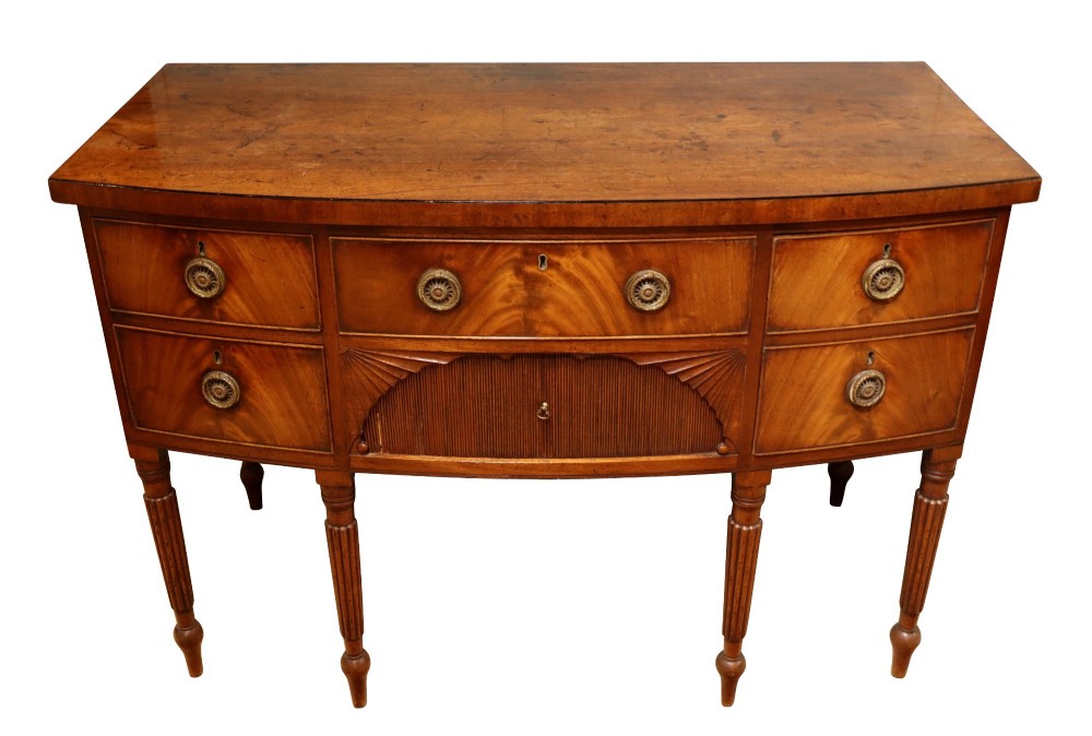 A Regency mahogany bow-fronted sideboard featuring a central drawer with tambour cupboard below, flanked by drawers and supported on six turned, fluted legs. View III