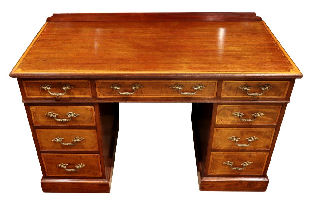 A late Victorian mahogany pedestal desk with satinwood stringing inlay, nine drawers, and brass handles. View III