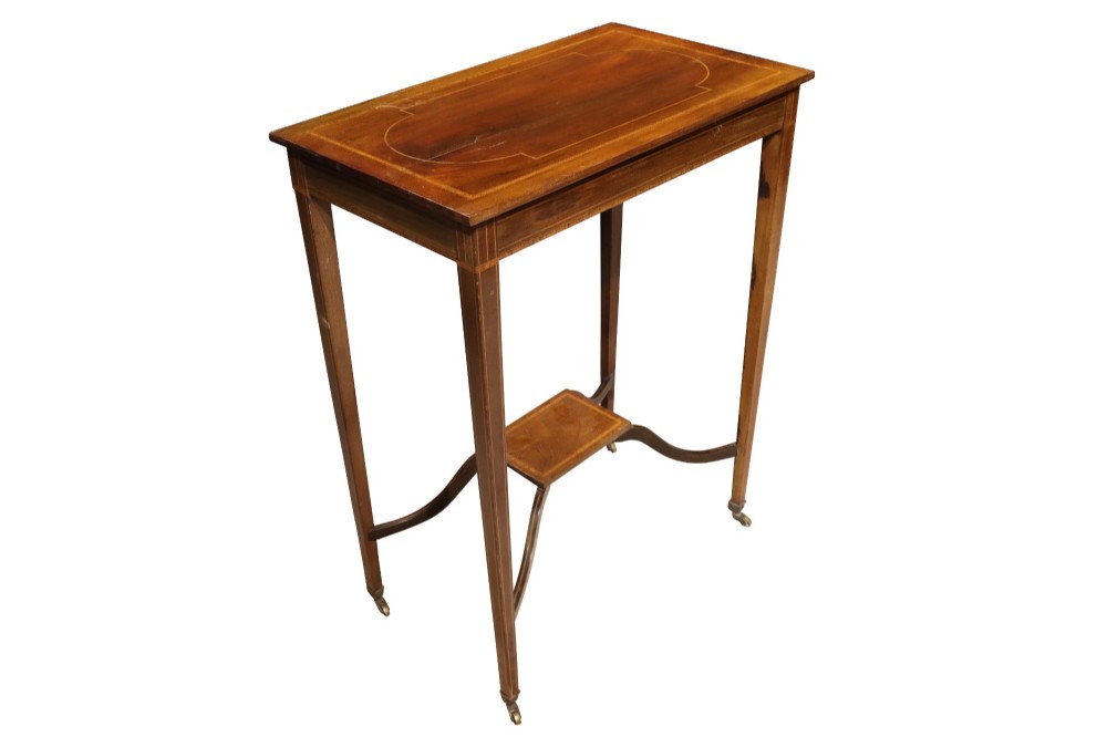 An Edwardian mahogany occasional table featuring a removable tray top with brass handles, satinwood string inlay, tapered legs, brass castors, and a lower X-form stretcher with a central platform. View II