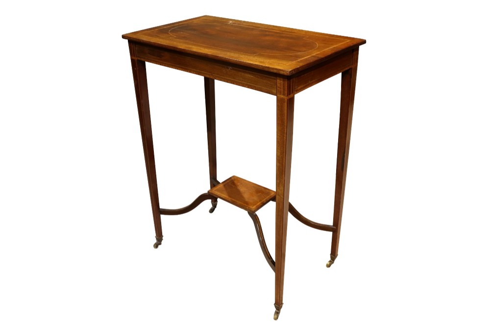 An Edwardian mahogany occasional table featuring a removable tray top with brass handles, satinwood string inlay, tapered legs, brass castors, and a lower X-form stretcher with a central platform. View IV